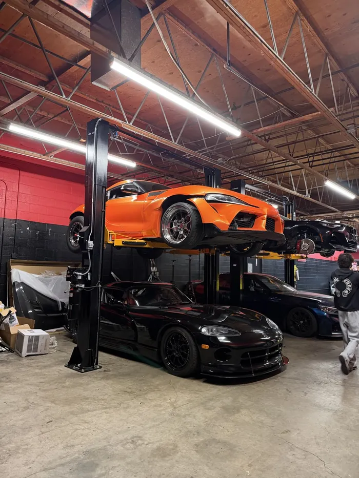 GR Supra on the lift above a Dodge Viper in the PSI bays