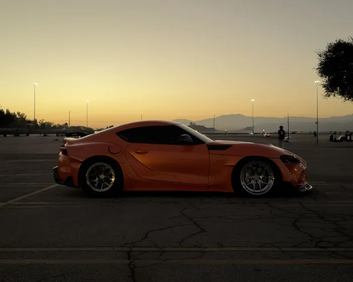 Orange Toyota GR Supra at sunset